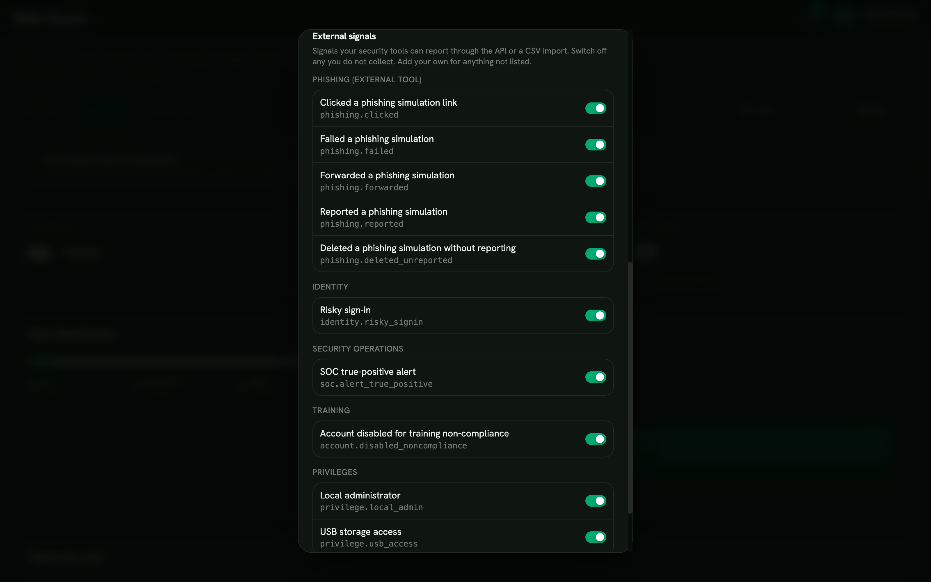 Scoring settings dialog listing the external signal catalog grouped by category, with phishing, identity, security operations, training, and privilege signals each toggled on, and a button to add a custom signal